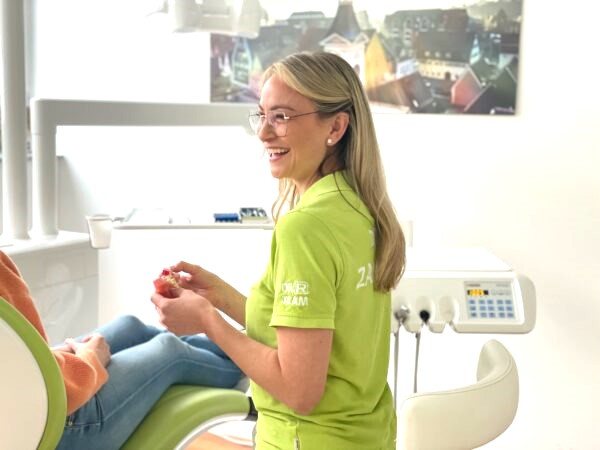 Lächelnde Kollegin im Behandlungszimmer der Praxis Dr. Rathgeber